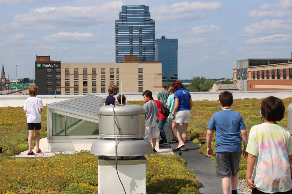 Students explore around the skylight on the rooftop garden
